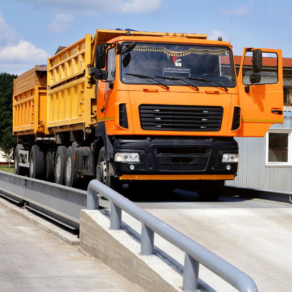 Orange Truck being weighed on weighbridge